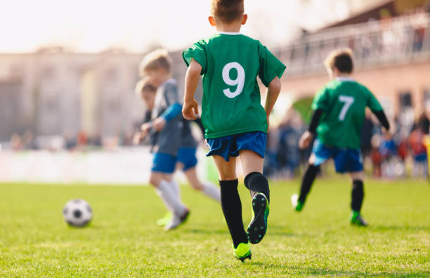 Boys playing in a soccer match. Football youth players kicking football ball in sunny day. Football competition tournament for kids